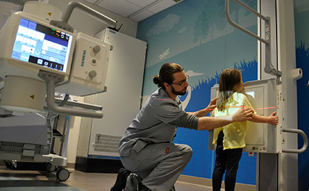 DMS tech positioning child for chest x-ray
