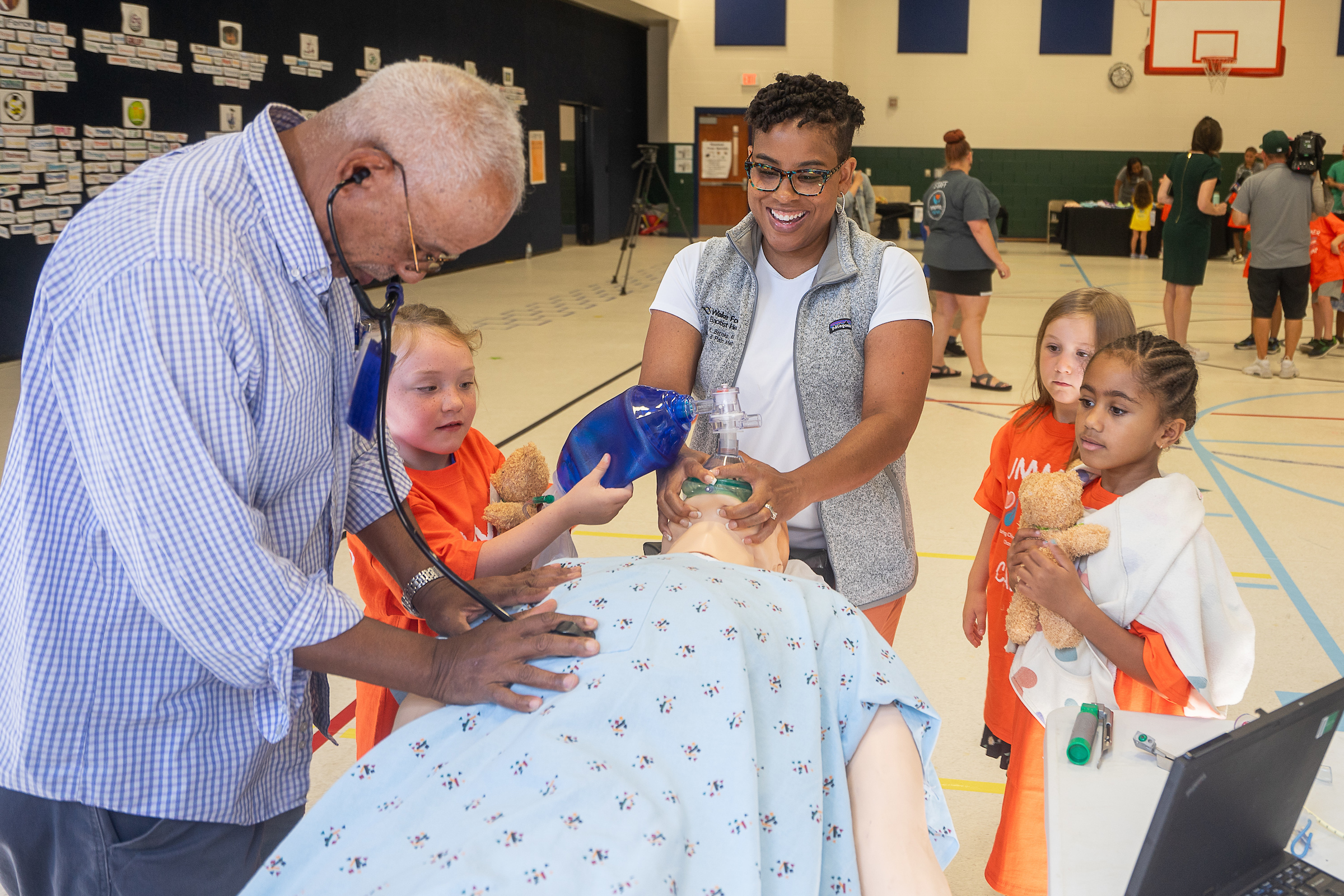 Amber Brooks leading a learning activity for a group of children with a medical dummy 