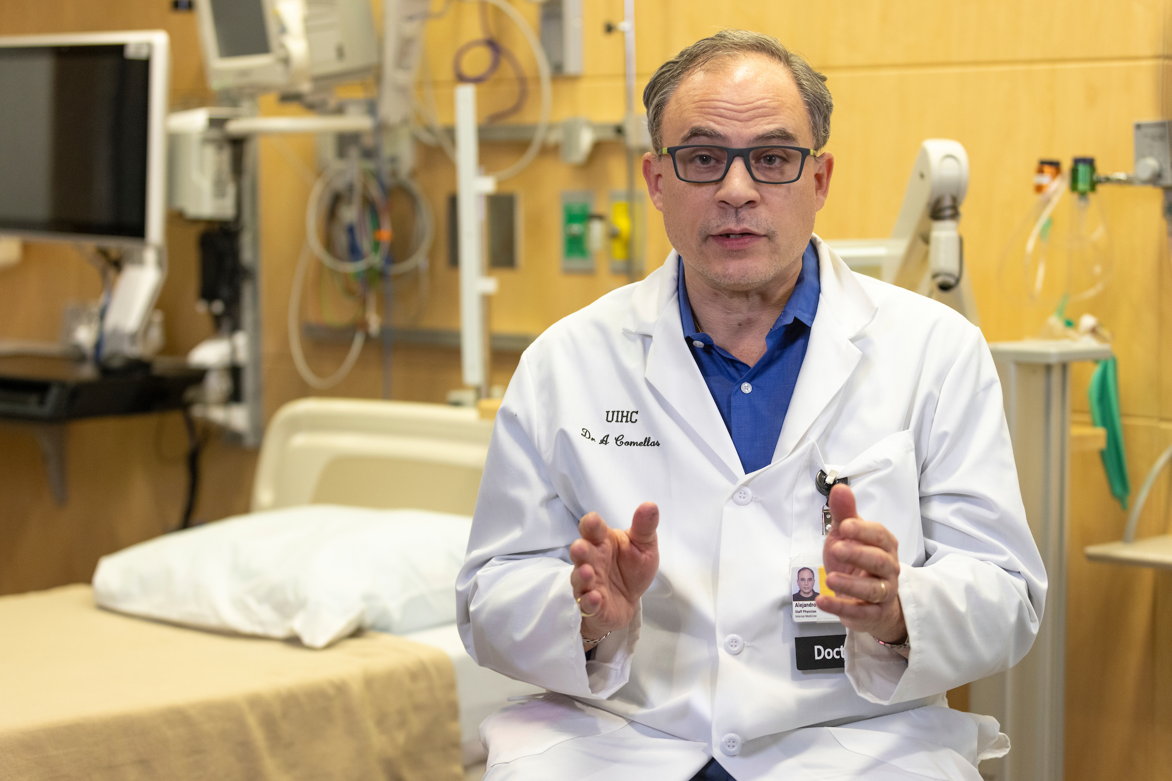 Alejandro Comellas speaks to the camera in a white coat in a hospital room.