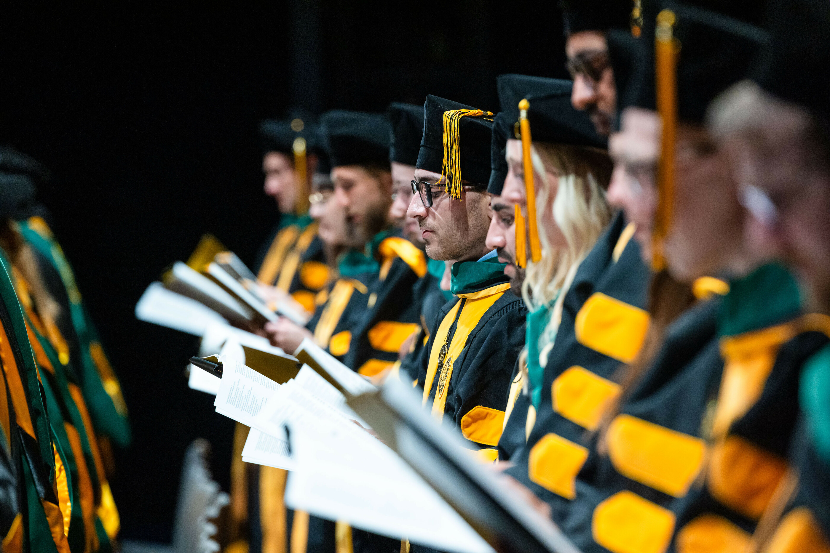 Group of students in graduation robes reading the Hippocratic Oath