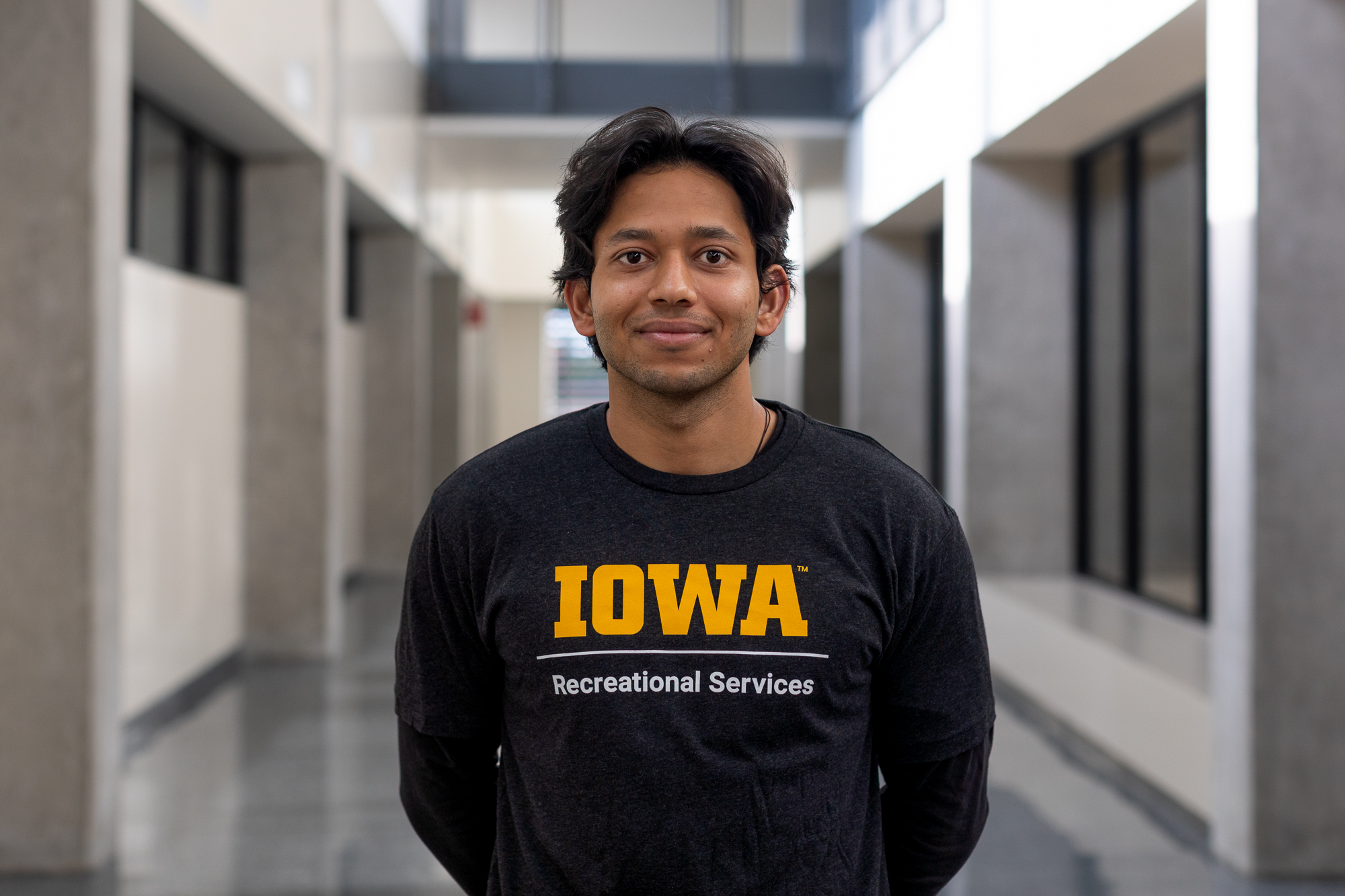 Ali Khan smiling and wearing a University of Iowa t-shirt