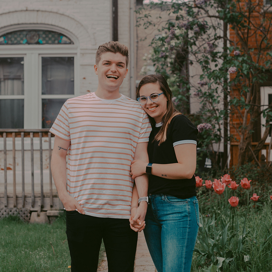 Jimmy and Nicole stand outdoors near a bed of tulips