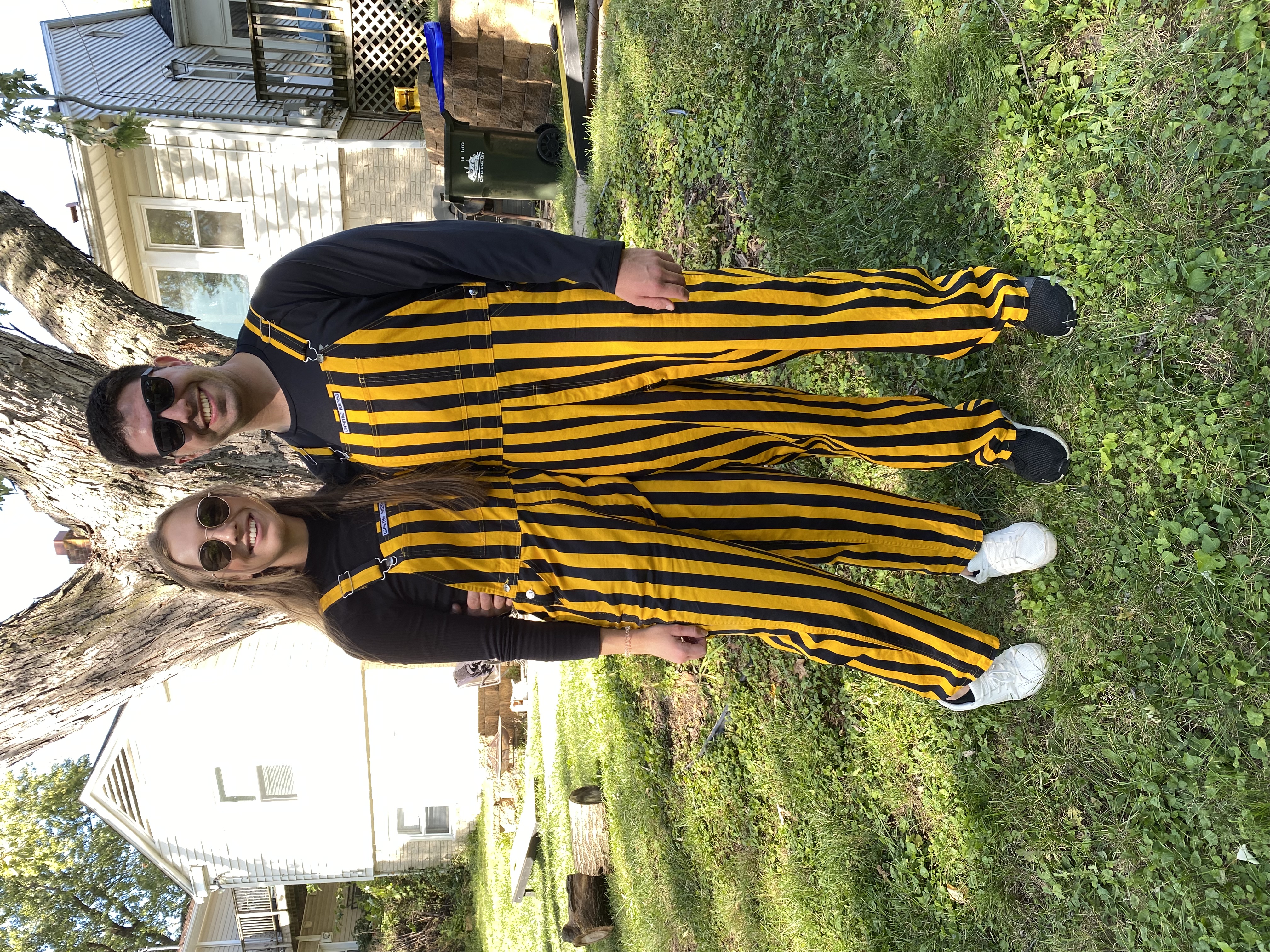 Jack Klein stands outdoors with his fiancee. Both are wearing gold and black striped game bibs.