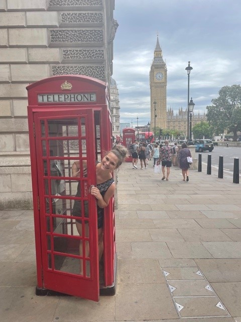 Stephanie Saey peeks out of a red telephone box in London.