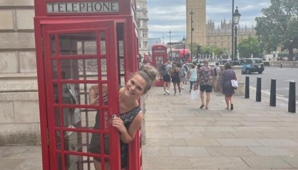Stephanie Saey peeks out of a red telephone box in London.