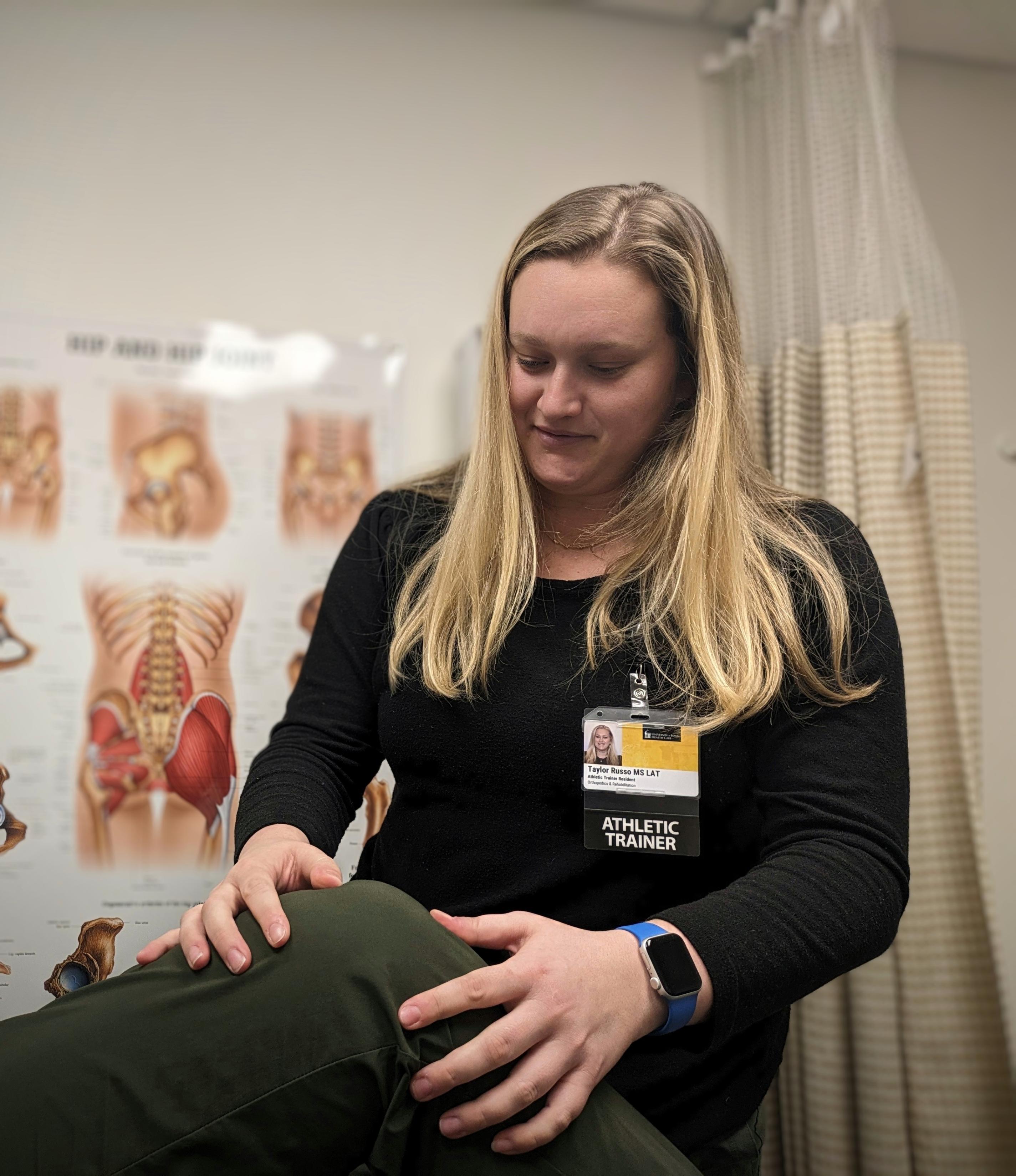 Taylor Russo, a resident physician in the athletic training program, works with a patient.