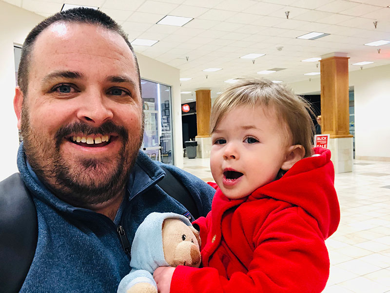 Andrew Goldstein holding a child