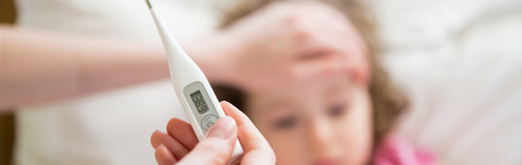 Care giver holds digital thermometer near patient