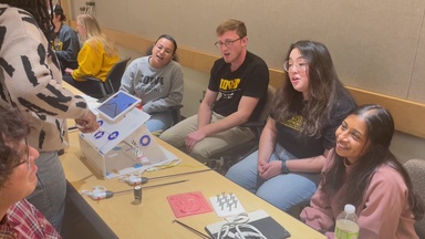 Medical students leading a laparoscopic surgery simulation activity with high school students