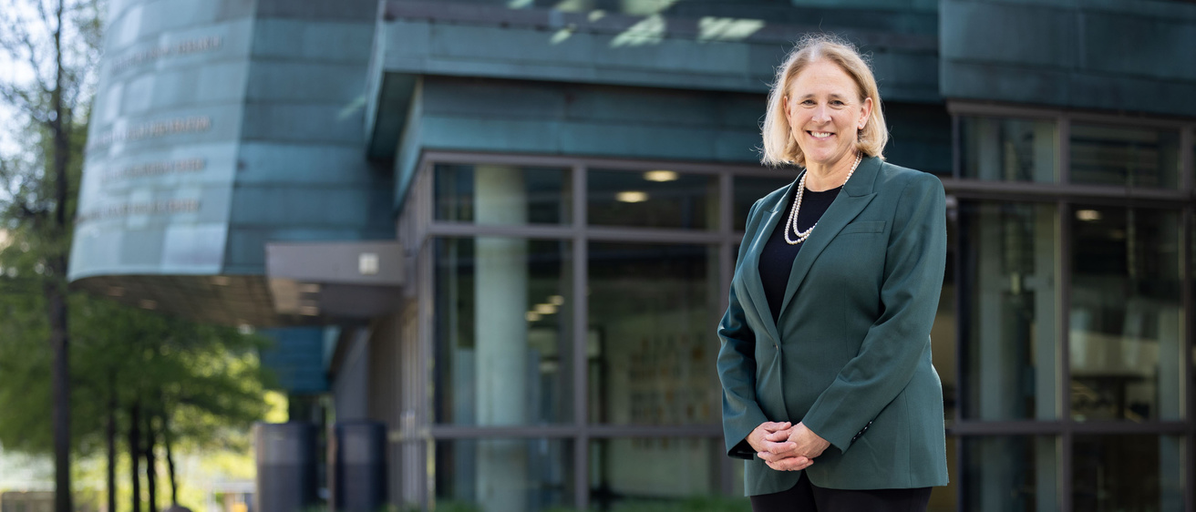 Dr. Jamieson standing in front of a College of Medicine building