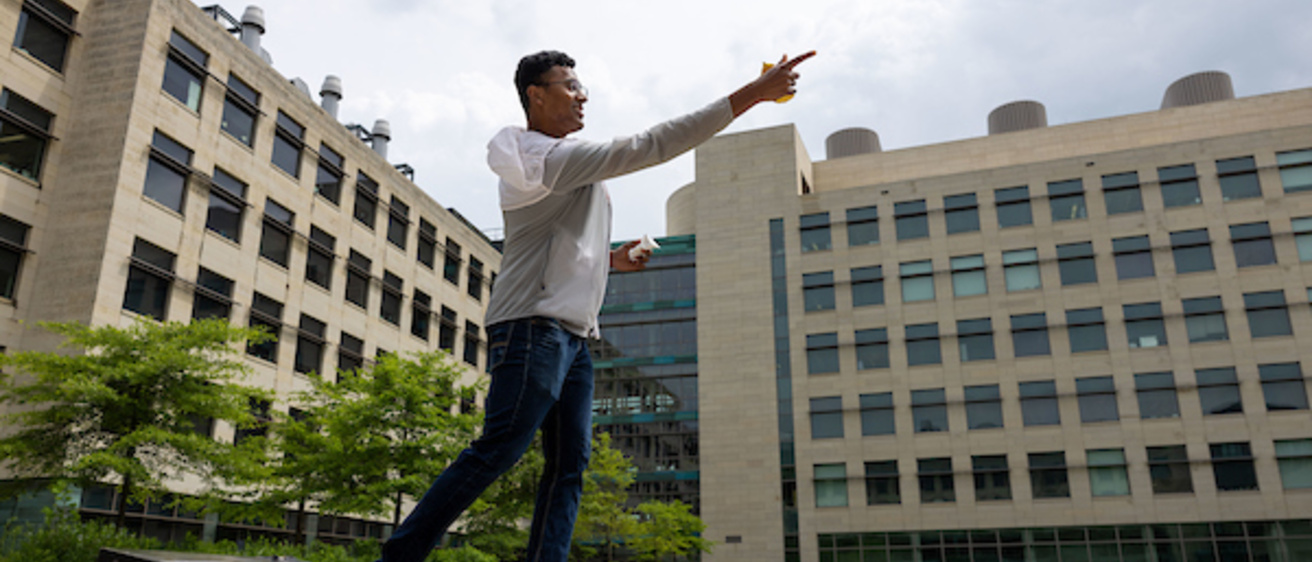 A student throws during a game of bags in the MERF courtyard